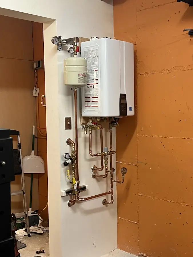 Plumbing technician inspecting water heater connections in Rocky Mount